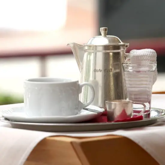 Klassisches Kaffee-Kännchen mit Tasse und einem Glas Wasser